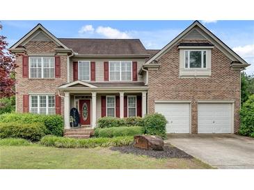 Charming brick two-story home with red shutters, well-manicured landscaping, and a welcoming front porch at 179 Bradshaw Park Dr, Woodstock, GA 30188