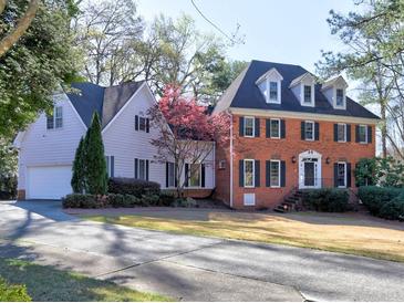 A beautiful two-story home features a brick facade, dark shutters, and a well-manicured front lawn at 3012 Asheton Ne Pl, Marietta, GA 30068