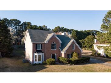 Charming two-story brick home featuring a well-manicured front yard and inviting curb appeal at 3152 Parks Run, Loganville, GA 30052