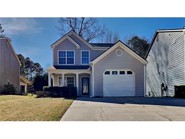 Charming two-story home with a gray exterior, attached garage, and well-maintained front lawn at 6599 Coventry Pt, Austell, GA 30168