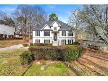 Charming two-story home with a well-maintained lawn and inviting front entrance and black shutters at 113 Willow Hill Ln, Stockbridge, GA 30281