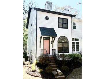 Charming two-story home with a light pink front door, neat landscaping and a stairway leading to the entrance at 2411 Charleston Oaks Ln, Decatur, GA 30030