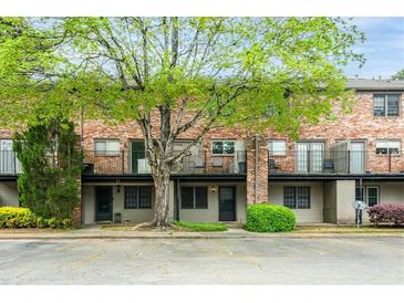 Charming brick townhouse with a mature tree in the front, offering a blend of classic style and natural beauty at 3087 Colonial Way # J, Atlanta, GA 30341