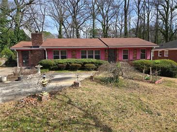 Charming single-story home with brick exterior, pink shutters, and mature landscaping at 1404 Aniwaka Sw Ave, Atlanta, GA 30311