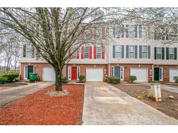 Charming townhomes with brick facades, colorful shutters, and attached garages for convenient parking at 3302 Waldrop Trl, Decatur, GA 30034