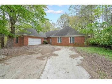 Sprawling red brick home with an attached two-car garage and mature landscaping around the front yard at 4367 S Berkeley Lake Nw Rd, Duluth, GA 30096