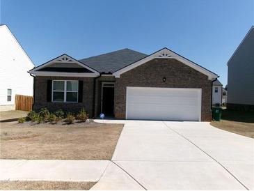 Charming single-story home with a brick facade and a two-car attached garage at 120 Montgomery Dr, Stockbridge, GA 30281