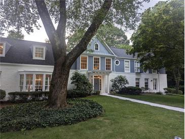 Charming two-story home with white brick and blue accents, complemented by lush greenery at 499 Johnson Ferry Nw Rd, Atlanta, GA 30328
