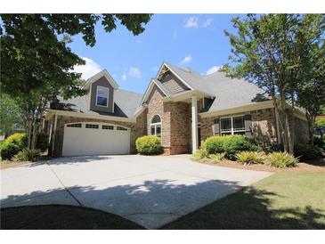 Charming brick home with a well-manicured lawn and a spacious driveway leading to a two-car garage at 1520 Camden Cove Dr, Cumming, GA 30040