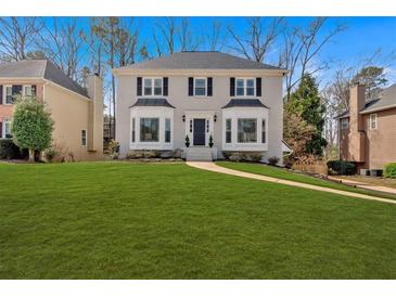 Traditional two-story home featuring black shutters, bay windows, and a lush green lawn at 2018 Sugar Maple Ln, Woodstock, GA 30189