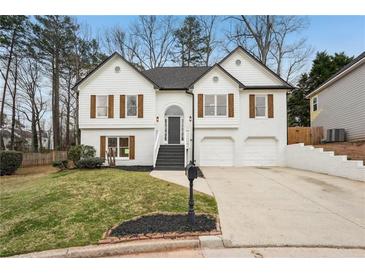 Charming two-story home with white brick and wood-accented shutters and manicured lawn at 4554 Alaspair Ln, Acworth, GA 30101