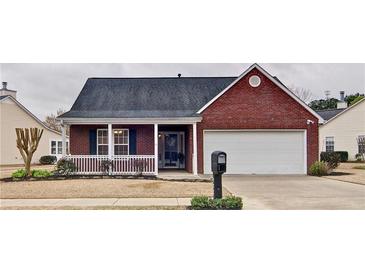 Charming brick home with a covered porch, well-maintained lawn, and an attached two-car garage at 732 Jacoby Dr, Loganville, GA 30052