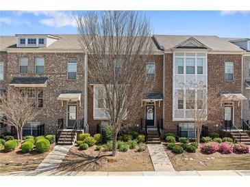 Charming brick townhome with manicured landscaping, featuring a welcoming front entrance and symmetrical facade at , Duluth, GA 30096