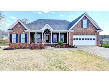 Charming single-story brick home with a manicured lawn and inviting front porch at 3426 Olivia Grace Way, Dacula, GA 30019