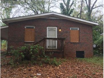 Quaint brick home with a traditional design and a cozy front porch and boarded windows at 511 Elmwood Nw Rd, Atlanta, GA 30318