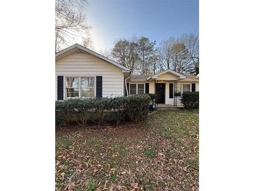 Charming single-story home with white siding, black shutters, and well-maintained landscaping at 1027 N Born Rd, Stone Mountain, GA 30088