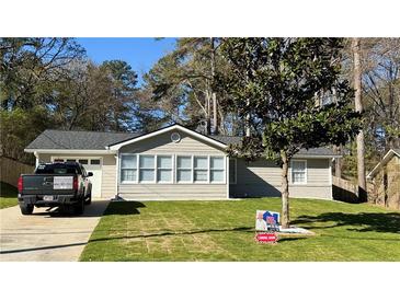 Charming home featuring a well-manicured lawn, light-colored siding, and a newly installed roof at 1655 Cherry Hill Sw Rd, Conyers, GA 30094
