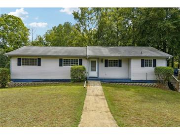 Charming single-story home with a well-manicured lawn, complemented by mature trees and lush greenery at 2415 Wales Dr, Austell, GA 30106