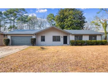 Charming single-story home with a well-maintained lawn and attached garage at 1463 Rockmoor Ct, Stone Mountain, GA 30088