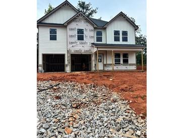 New construction home featuring two-car garage, covered porch, and unfinished landscaping at 740 Great Oak Pl, Villa Rica, GA 30180