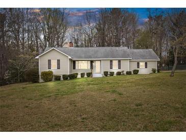 Charming one-story home with mature trees and a spacious front yard at 1312 Milstead Ave, Conyers, GA 30012