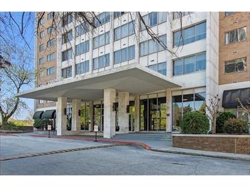 Exterior view of the building entrance featuring a covered driveway, stone columns, and glass doors at 215 Piedmont Ne Ave # 2205, Atlanta, GA 30308