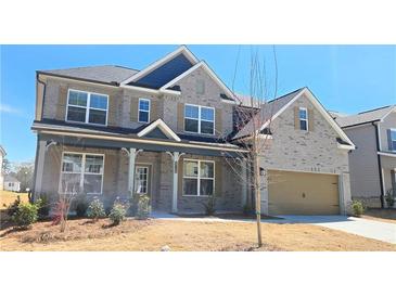 Charming two-story home boasts brick facade, two-car garage, manicured lawn, and shuttered windows at 2644 Mourning Dove Drive (Lot 40), Grayson, GA 30017