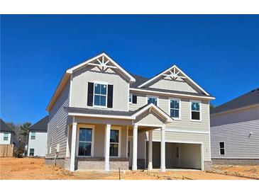 Two story home with bright siding, black shutters, and a two-car garage at 2704 Mourning Dove Dr Lot 34, Grayson, GA 30017