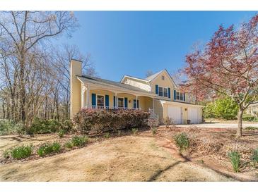 Charming two-story home featuring a front porch, blue shutters, and a two-car garage at 45 Somerset Ct, Covington, GA 30016