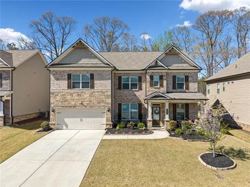 Charming two-story brick home with well-manicured lawn and attached two-car garage at 365 Henson Farm Dr, Loganville, GA 30052