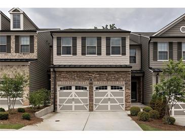 Charming townhome with stone accents, two-car garage, and neutral color palette at 257 Stone Park Dr, Woodstock, GA 30188