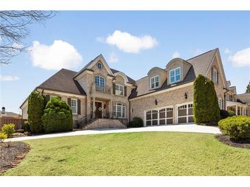 Stately brick home with manicured lawn, three-car garage and inviting entryway at 2770 Wooded Hills Walk, Marietta, GA 30062