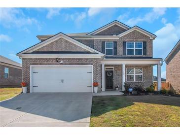 Charming two-story brick home with a well-manicured lawn and a two-car garage at 294 Broder Farms Dr, Stockbridge, GA 30281
