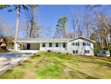 Charming single-story home featuring a long driveway and a covered carport at 2447 Old Peachtree Rd, Duluth, GA 30097