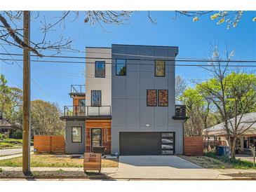 Modern three-story home boasts gray siding, a glass-enclosed balcony, and an attached two-car garage at 548 Fletcher St, Atlanta, GA 30310