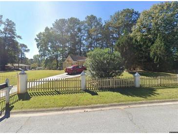 Charming single-story home with a picket fence and well-maintained front yard at 804 E Glochester Pl, Norcross, GA 30071