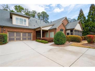 Charming brick home featuring a two-car garage and a beautifully landscaped front yard at 120 Chastain Nw Rd # 1204, Kennesaw, GA 30144