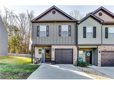 Charming townhome featuring a well-manicured lawn, a garage, and a welcoming front porch at 1709 Creel Ln, Atlanta, GA 30349