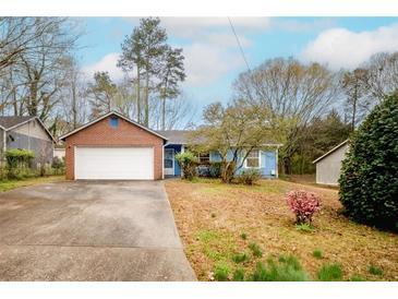 Charming brick and siding home with a two-car garage and a well-maintained front lawn at 2410 Deep Shoals Cir, Decatur, GA 30034