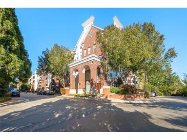 Beautiful brick condo building with manicured landscaping, trees, and a charming architectural design at 1850 Cotillion Dr # 1008, Atlanta, GA 30338