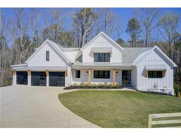 Modern farmhouse with three-car garage, board and batten siding, and professional landscaping at 555 Lower Birmingham Rd, Canton, GA 30115