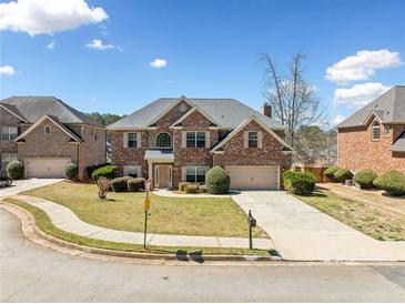 Beautiful brick home features a well-manicured lawn, two-car garage, and classic architectural details at 50 Riverstone Dr, Covington, GA 30014