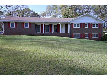Charming brick home with well-manicured lawn, red shutters, and inviting front porch at 5235 Pounds S Dr, Stone Mountain, GA 30087