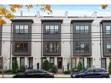 Modern townhome exterior showing the white painted brick, black window trim and lush landscaping at 574 Boulevard Ne Pl # 14, Atlanta, GA 30308