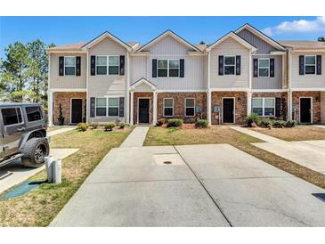 Inviting townhouse exterior featuring brick accents and a well-maintained lawn at 6036 Oakley Rd, Union City, GA 30291