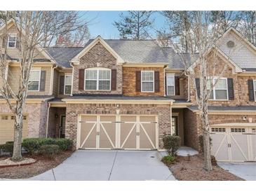 Charming townhome featuring a brick facade, two-car garage, well-maintained landscaping, and inviting curb appeal at 4221 Weavers White Ln # 18, Austell, GA 30106