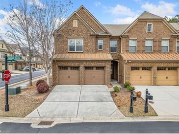 Attractive brick townhome featuring attached garages and well-maintained landscaping at 2105 Caswell Cir, Marietta, GA 30060