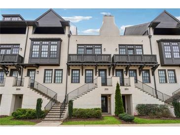 Charming townhome with a painted brick facade, black trim, and inviting staircases leading to covered entryways at 6682 Sterling Dr, Atlanta, GA 30328