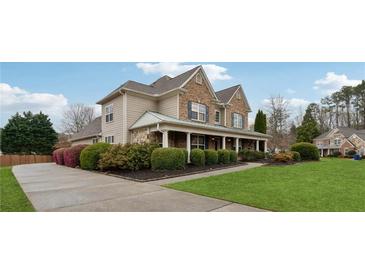 Charming two-story home features a welcoming front porch, well-manicured lawn and lush landscaping at 1527 Sage Ridge Dr, Marietta, GA 30064