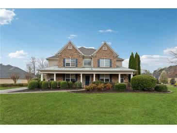 Charming brick home with a well-manicured lawn, mature trees, and inviting front porch at 1527 Sage Ridge Dr, Marietta, GA 30064